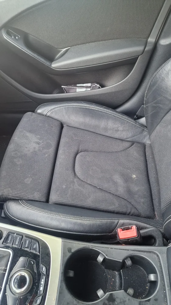 Audi passagiersstoel vóór interieurreiniging met zichtbare vlekken op de bekleding