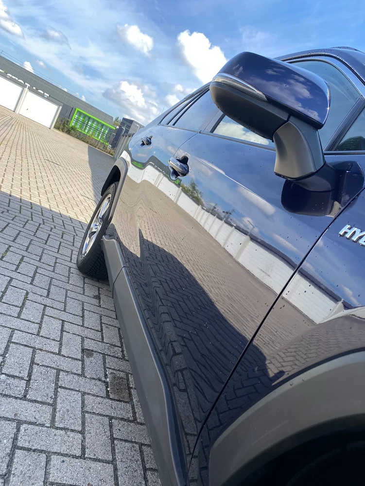 Detail van de blauwe Toyota-lak met duidelijke reflecties in de deur